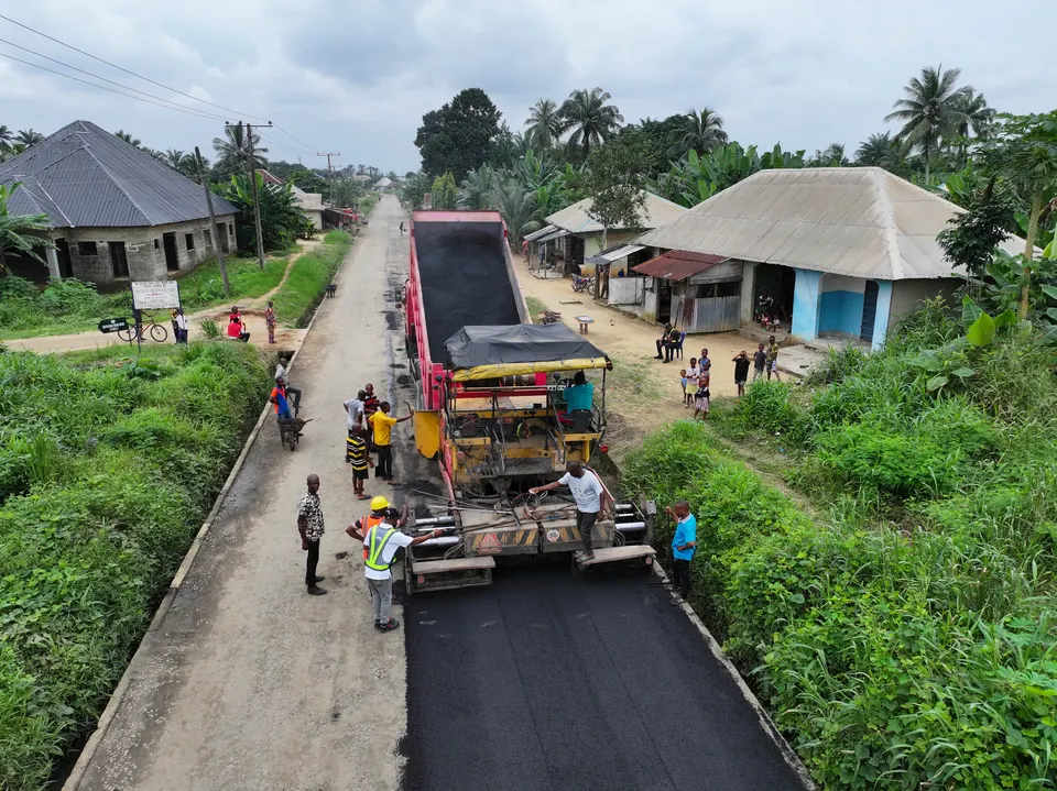 Aerial view of a paving crew laying asphalt through a community road
