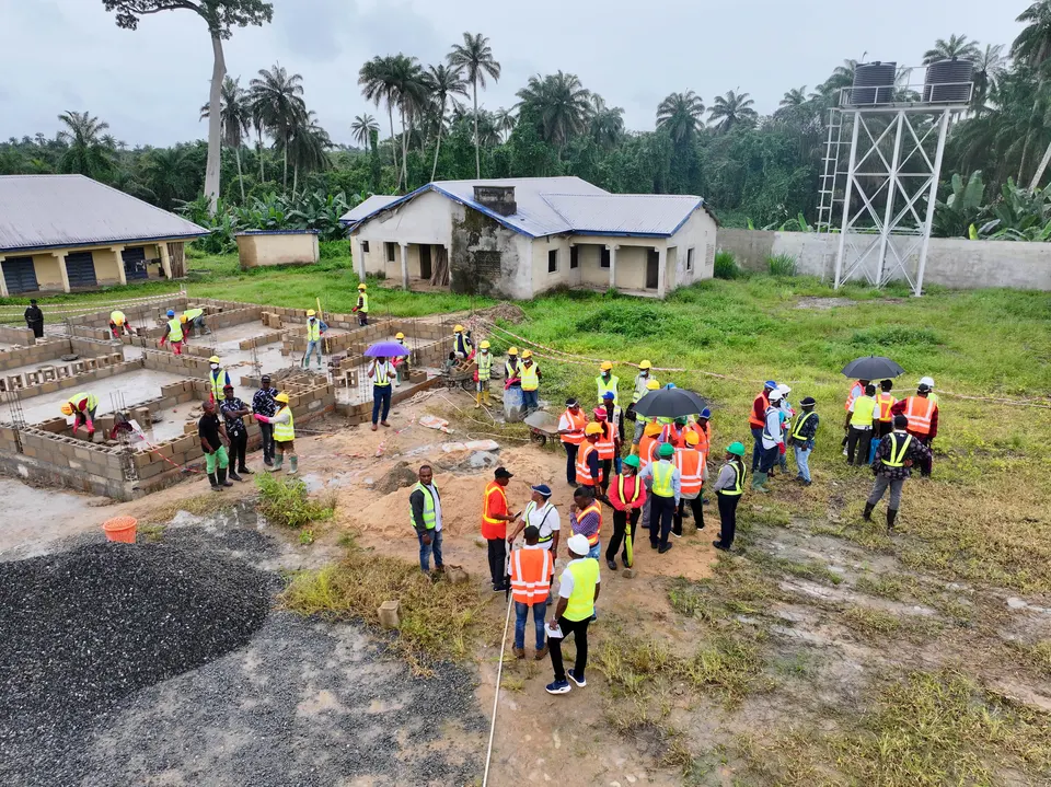 A large construction team gathered beside active foundation work